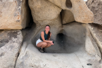 Sydney crouches on some rocks.