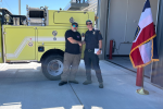 Pila Malolo, WDD AFMO, and Dan Walton, Tooele County Fire Warden, shake hands in front of a Type-6 engine.