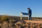 A visitor to the Valley of Fires Recreation Area reads a new interpretive sign at the start of the Malpais Nature Trail on Jan. 16.