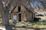 A stone cabin with a signpost in front identifying it as a cultural resource.
