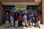 Group of students and adults posing outside a school entrance under a "Career Day" banner dated March 6, 2020.