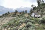 Law enforcement vehicle on a dirt road with mountain landscape 