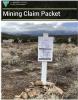 landscape with rock pile and mining claim notice posted on a white sign stuck into a pile of rocks