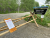 Wooden fence with CLOSED sign blocking road. Sundance Lodge Recreation Area sign on the side of the road. 