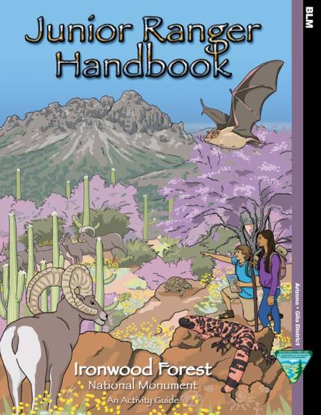 Cover of Ironwood National Monument Junior Ranger handbook which shows two children, a bat overhead, and some bighorn sheep as well as a landscape with many saguaro cacti.