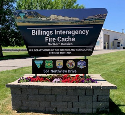 BLM Sign in front of Fire Cache Building. Text: Billings Interagency Fire Cache Northern Rockies