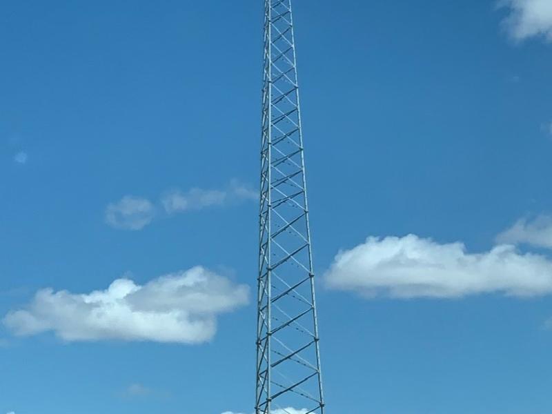 large cell tower in the open landcape with blue skies and clouds