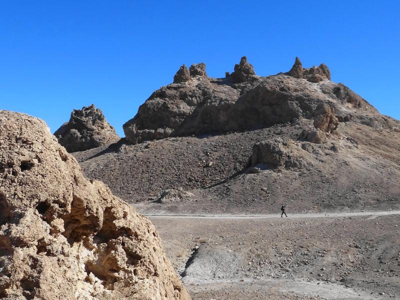 hiker walking on a lone trail in a desert