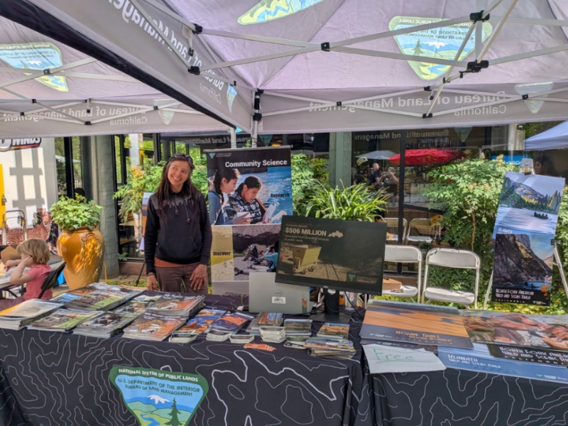 BLM employee stands at a booth at the sacramento zoo