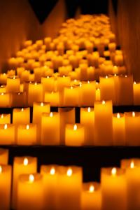 Rows of glowing candles illuminating a dark stairway, creating a warm, serene atmosphere.
